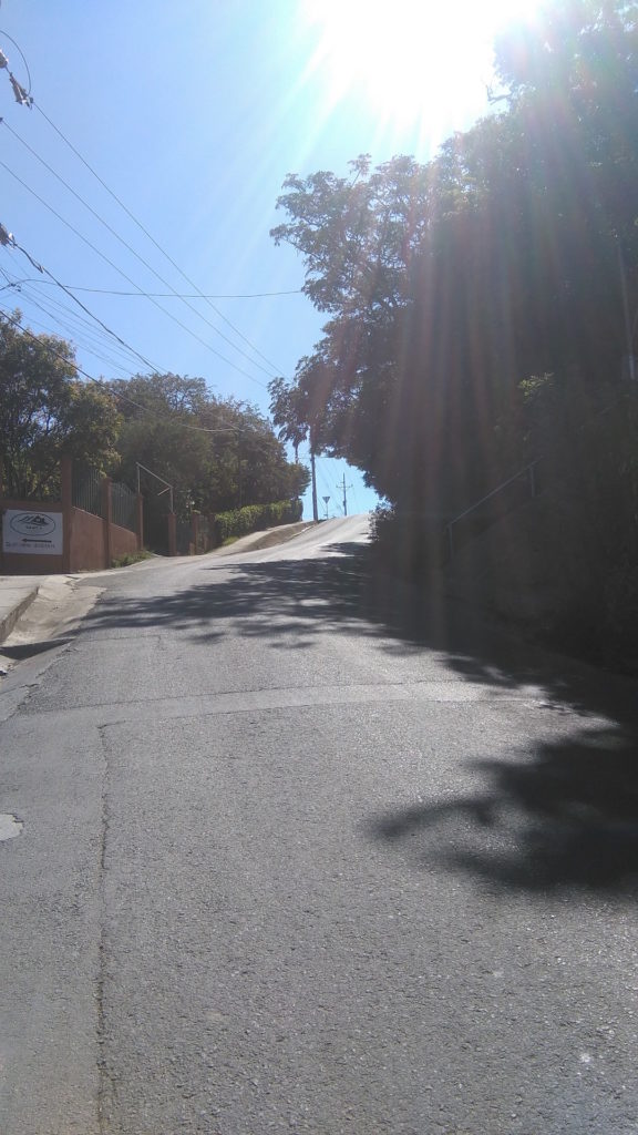 View from the main road coming up, where other drivers make left turns in front of us just as you crest the hill. Squint and you'll see the new yield sign at the top left.